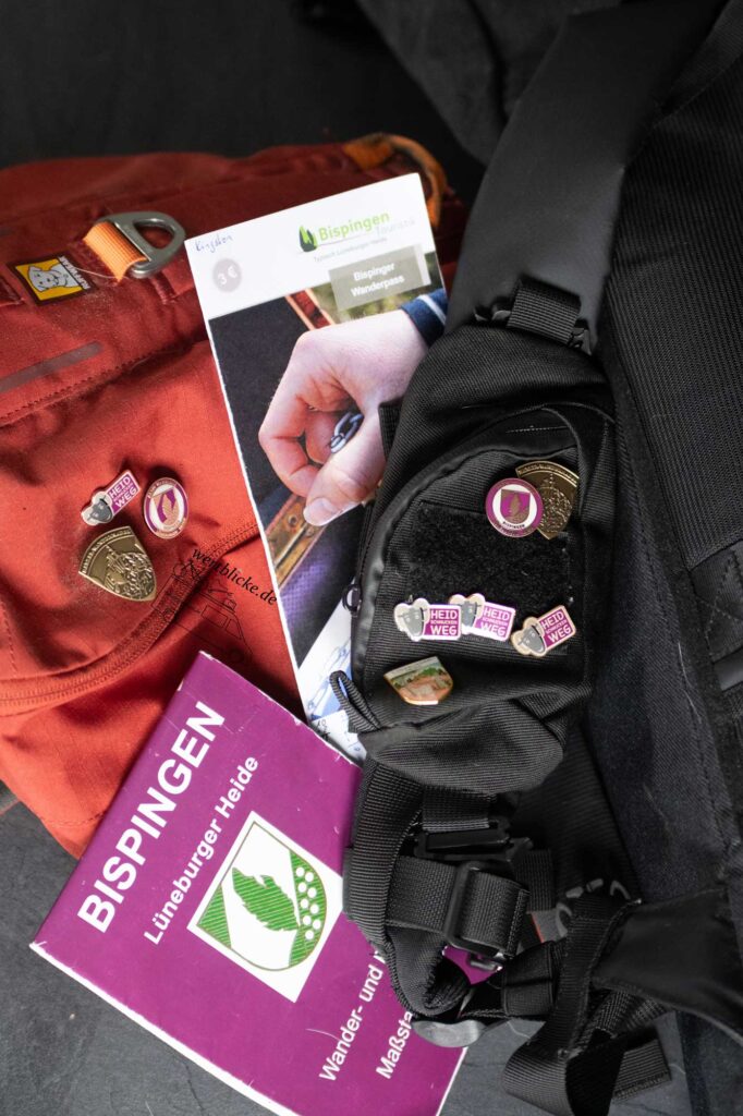 Pins des Heidschnuckenwegs und Harzer Wandernadel an Hundegeschirr und Rucksack